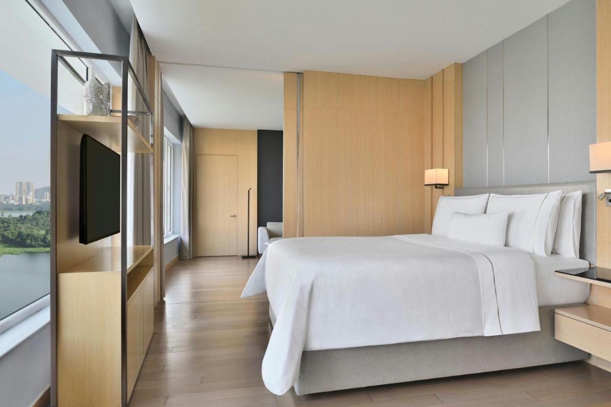 a hotel room with a bed and a television at The Westin Mumbai Powai Lake in Mumbai