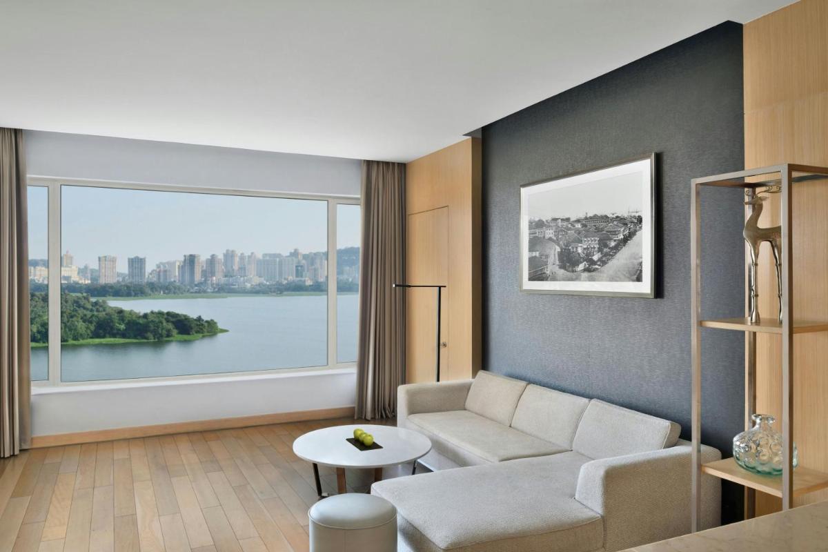 a living room with a couch and a large window at The Westin Mumbai Powai Lake in Mumbai