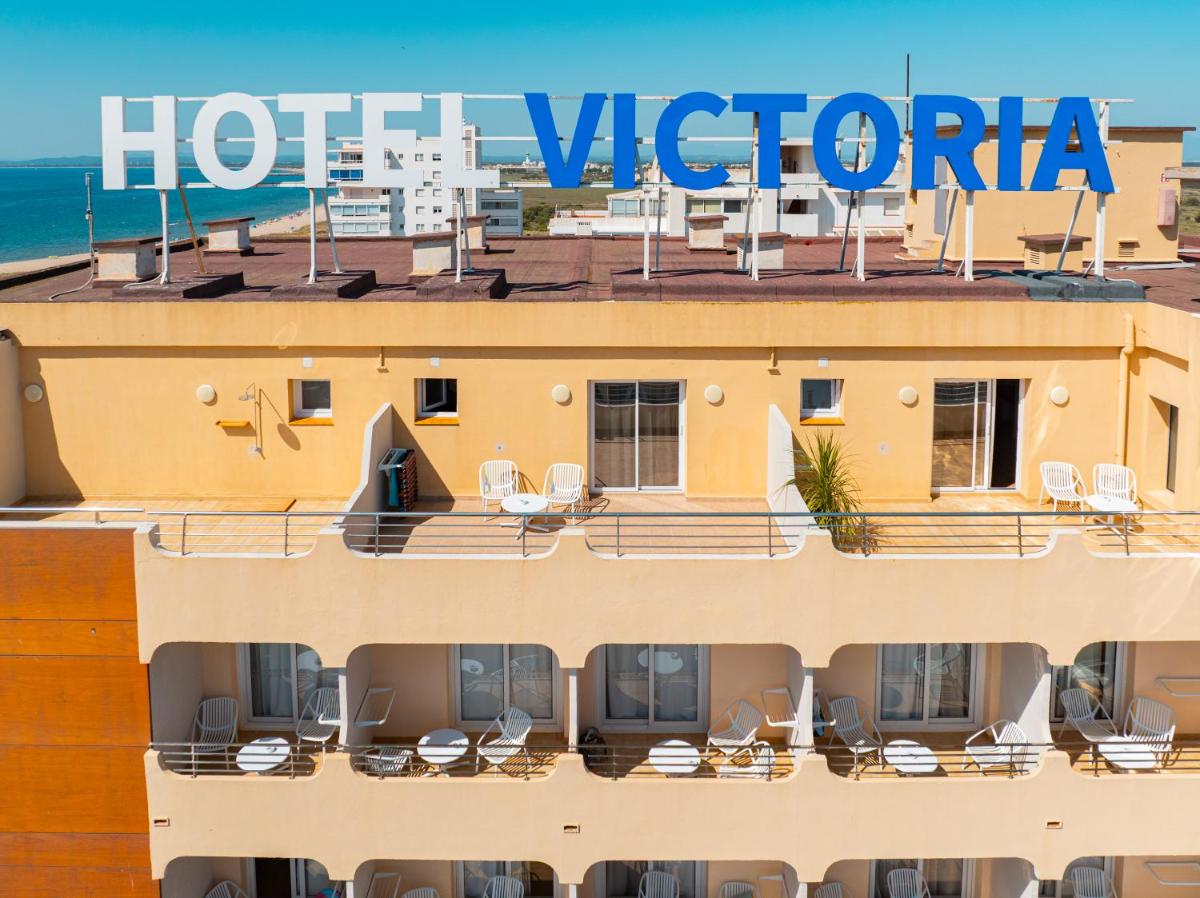 un hotel con una señal de hotel en la parte superior de un edificio en Prestige Victoria, en Roses