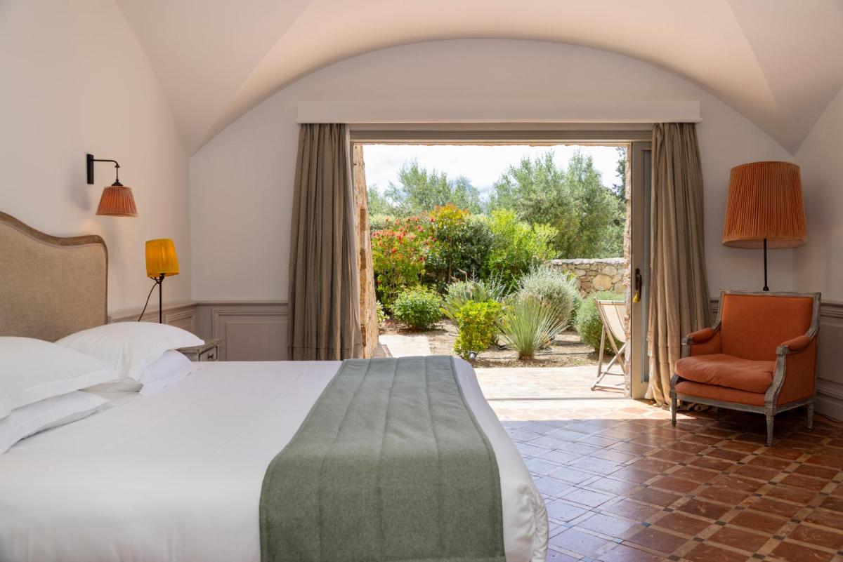 une chambre avec un lit, une chaise et une fenêtre dans l'établissement La Signoria & Spa, à Calvi