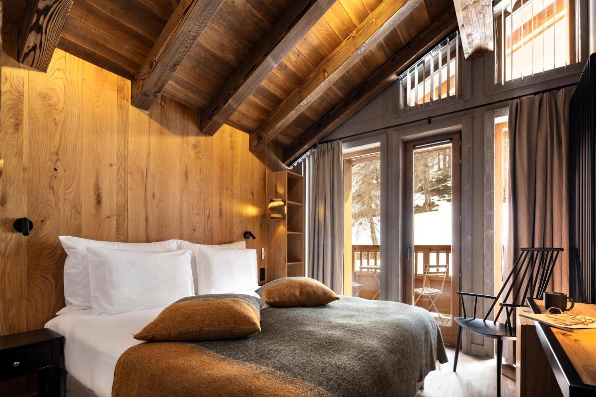 une chambre avec un lit, un bureau et des fenêtres dans l'établissement Hotel MONT-BLANC VAL D'ISERE, à Val dʼIsère