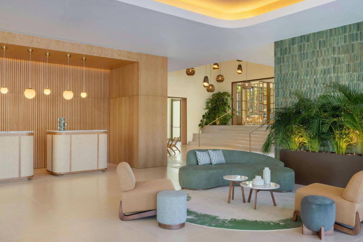 um saguão com um sofá, cadeiras e uma mesa em The Westin Salgados Beach Resort, Algarve em Albufeira