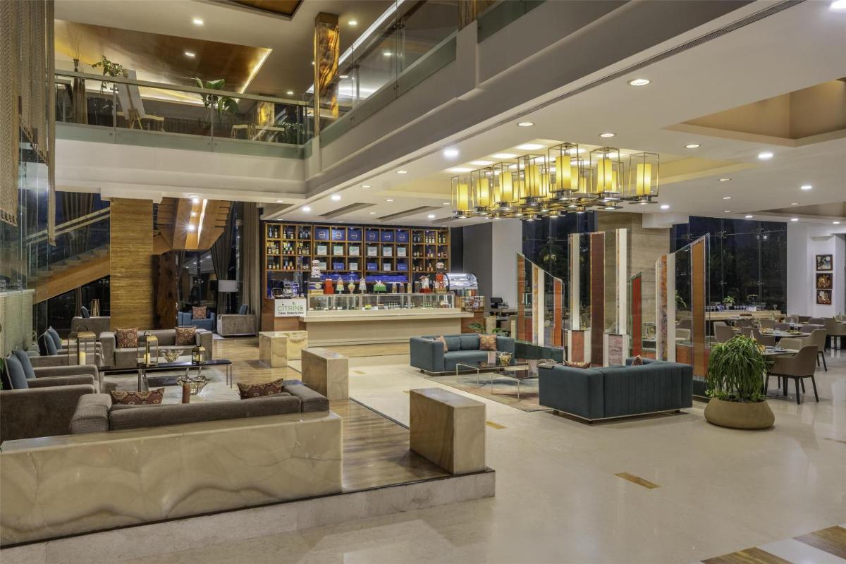 a lobby with couches and tables in a library at Radisson Blu Hotel Pune Kharadi in Pune