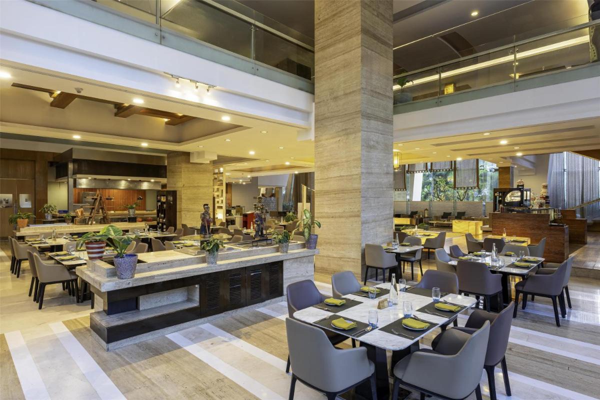 a restaurant with tables and chairs and a bar at Radisson Blu Hotel Pune Kharadi in Pune