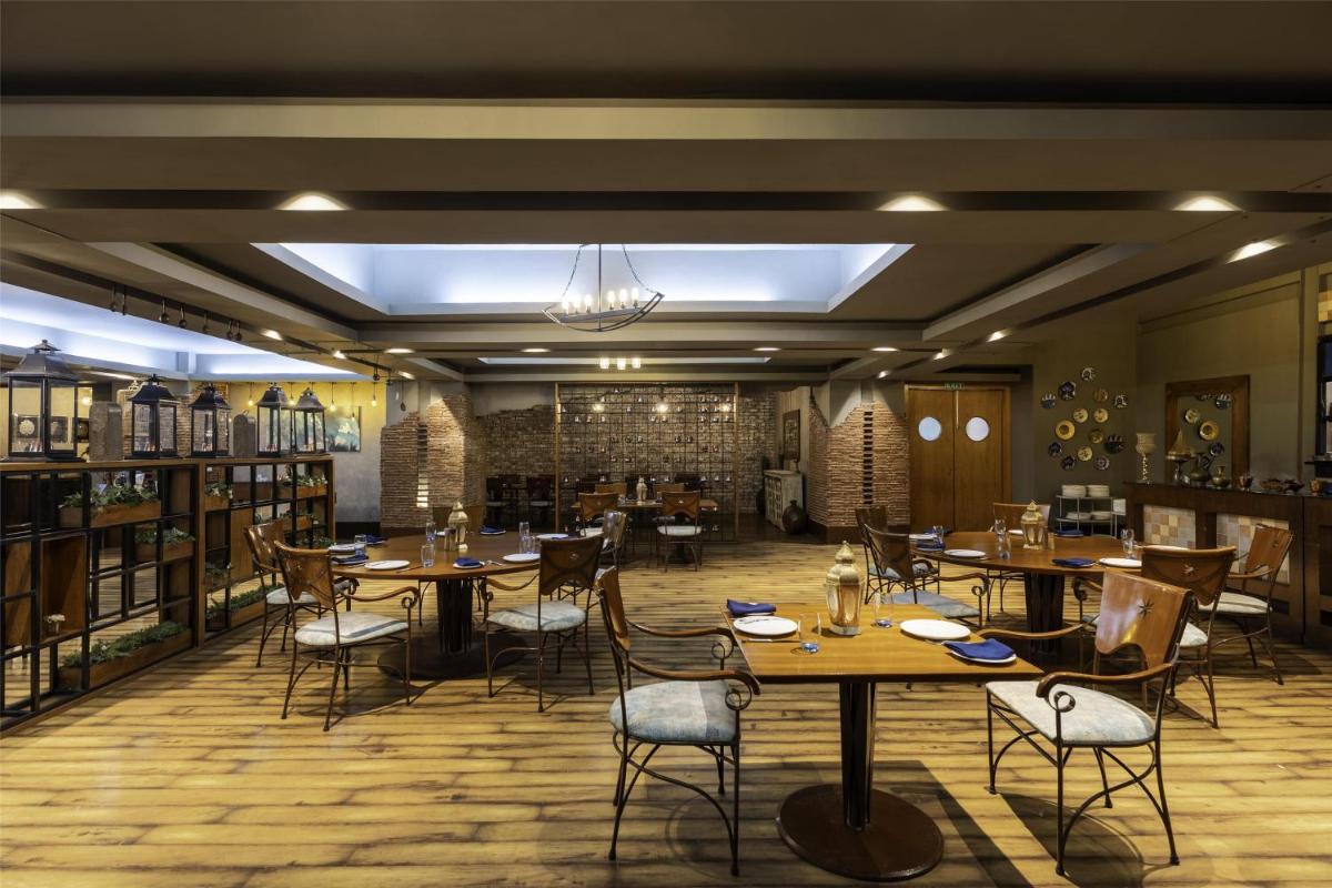 a restaurant with tables and chairs in a room at Radisson Blu Hotel Pune Kharadi in Pune