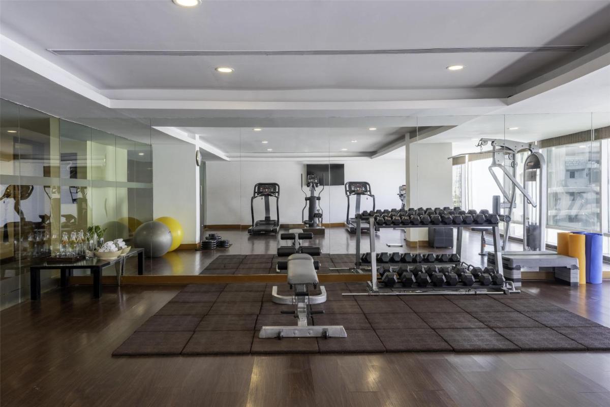 a gym with several treadmills and exercise equipment at Radisson Blu Hotel Pune Kharadi in Pune