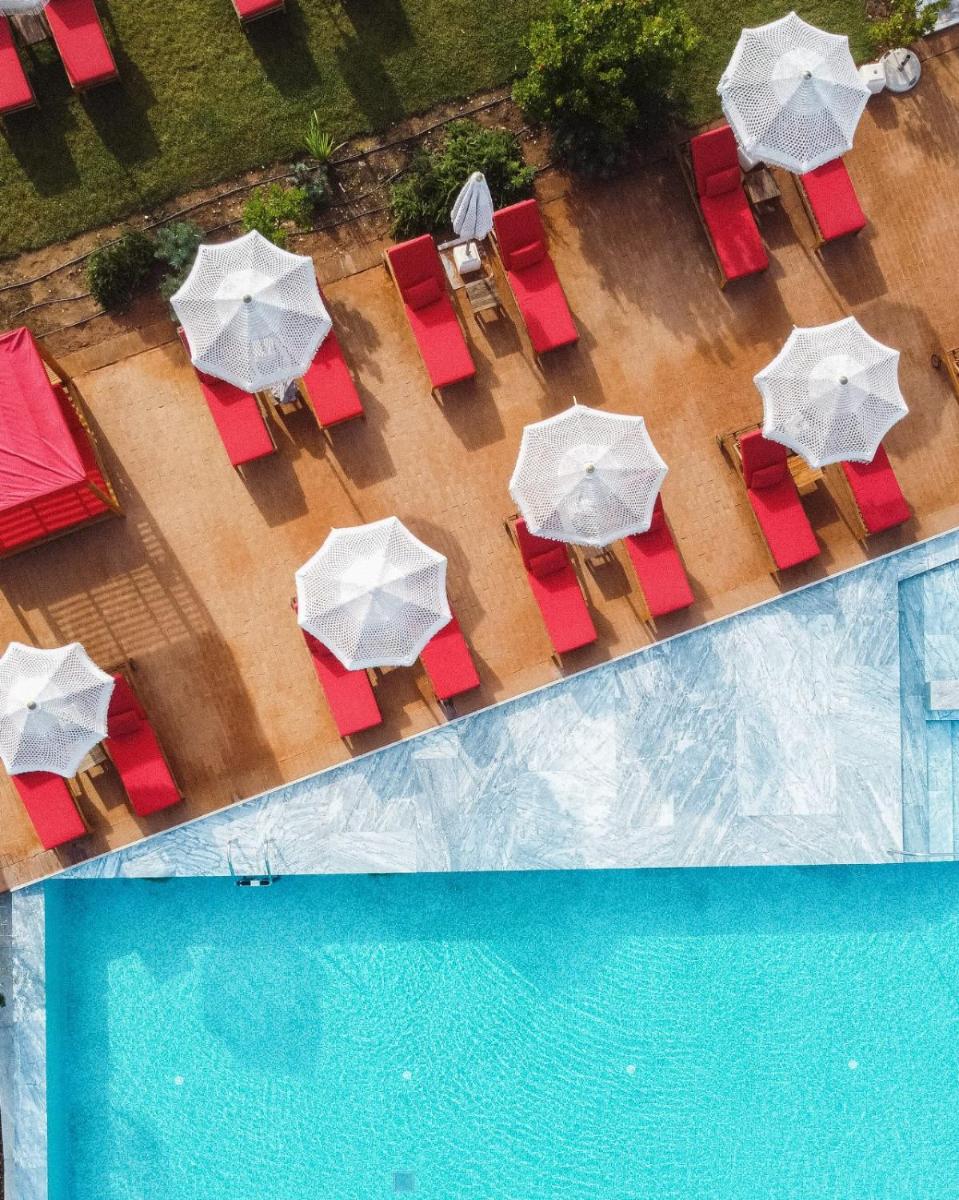 uma vista aérea de cadeiras e guarda-sóis ao lado de uma piscina em Praia do Canal Nature Retreat - Small Luxury Hotels of the World em Aljezur