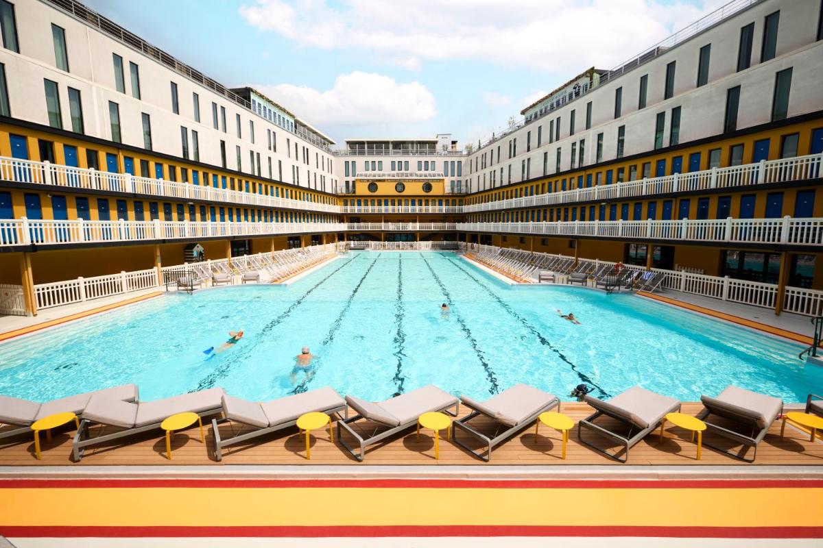 une grande piscine dans un grand bâtiment dans l'établissement Molitor Hotel & Spa Paris - MGallery Collection, à Paris
