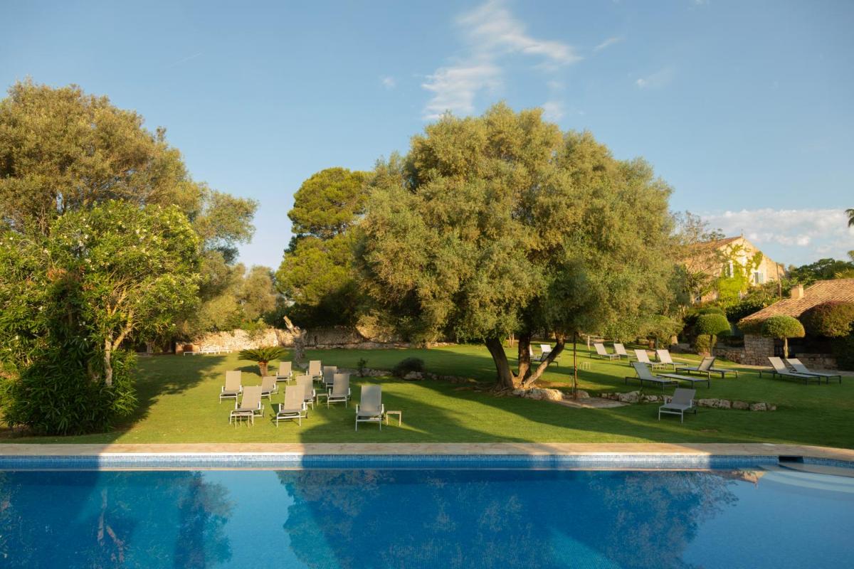 un complejo con piscina, sillas y árboles en Reserva Rotana Golf Resort, en Manacor