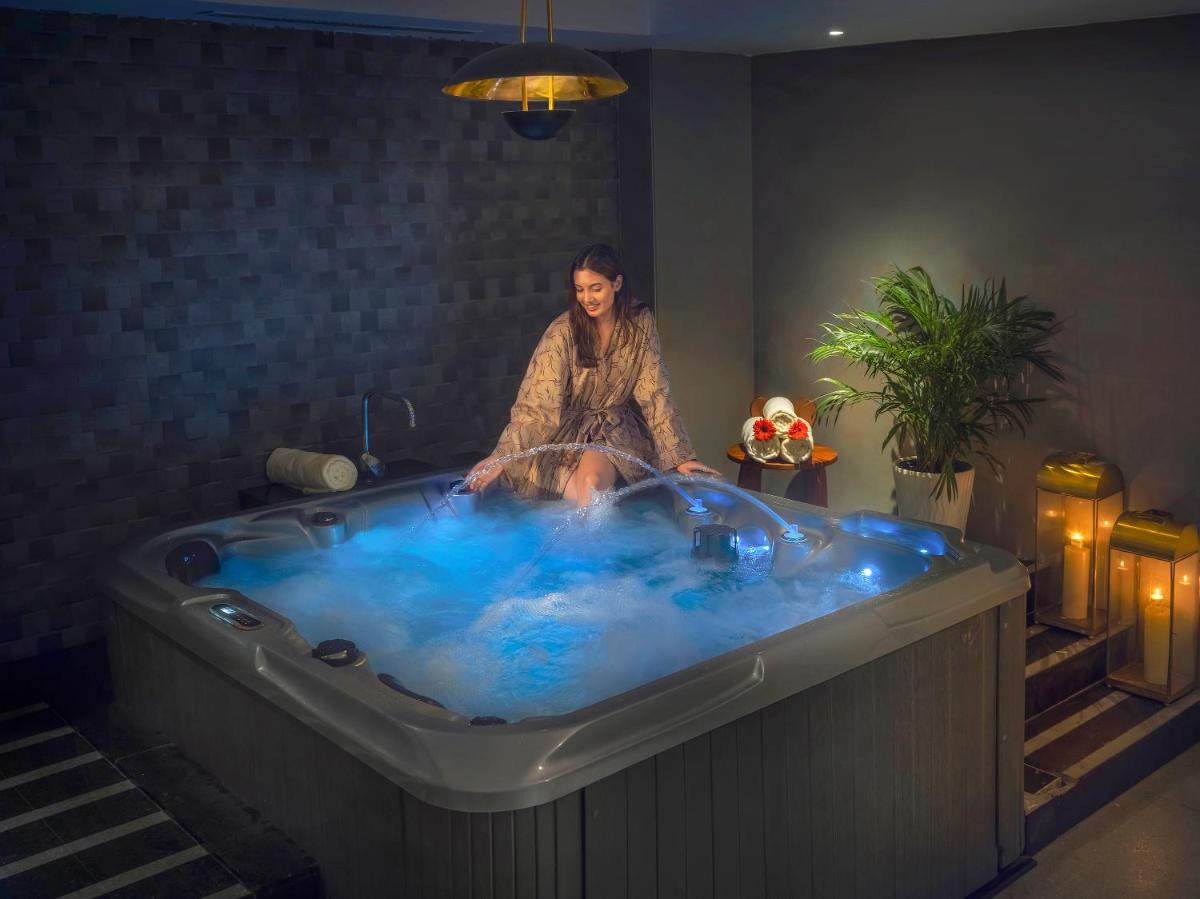 a woman sitting in a tub in a room at O by Tamara, Trivandrum in Trivandrum