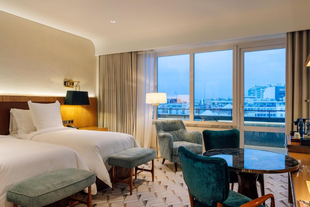 um quarto de hotel com duas camas, uma mesa e cadeiras em Four Seasons Hotel Ritz Lisbon em Lisboa mais 71 fotografias