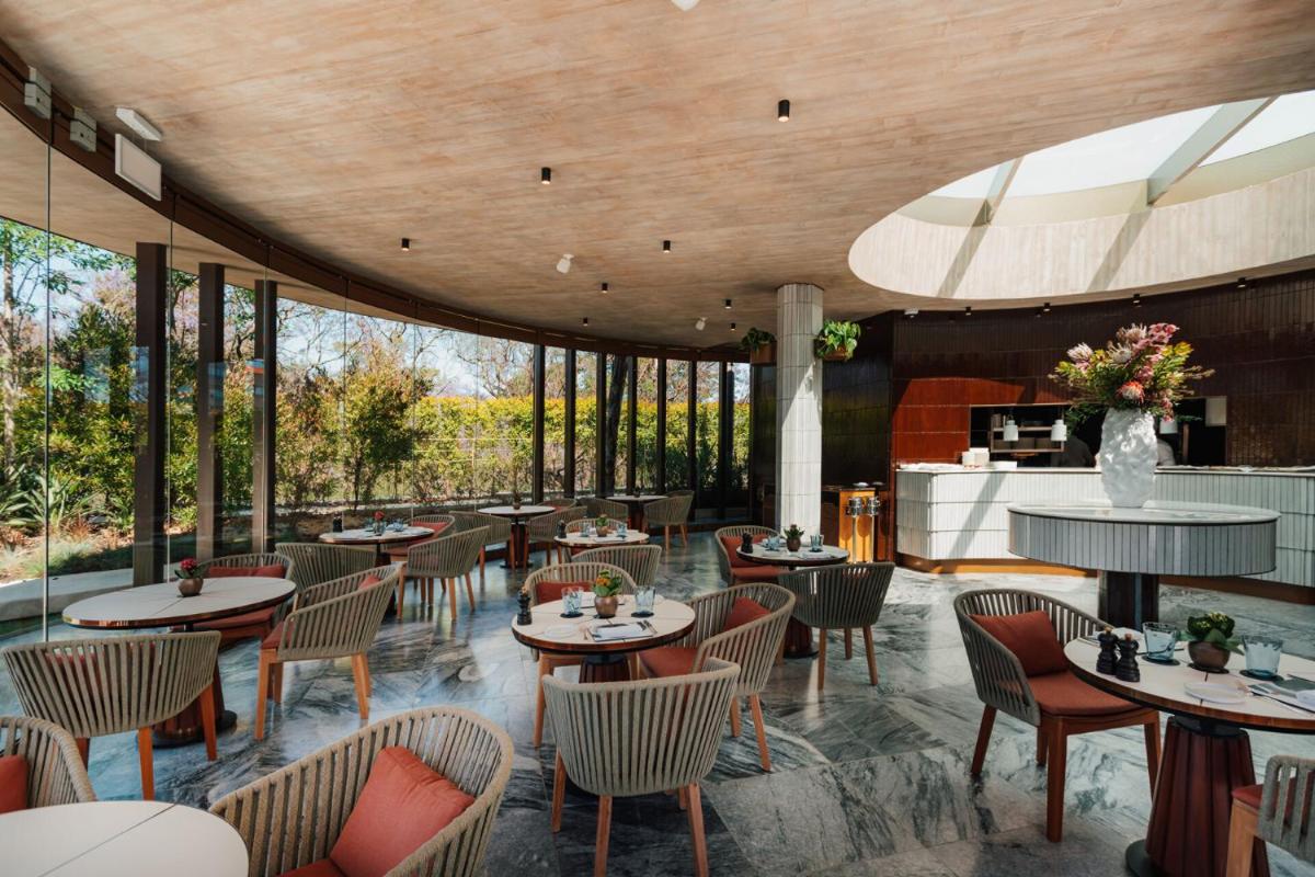 um restaurante com mesas, cadeiras e janelas em Four Seasons Hotel Ritz Lisbon em Lisboa