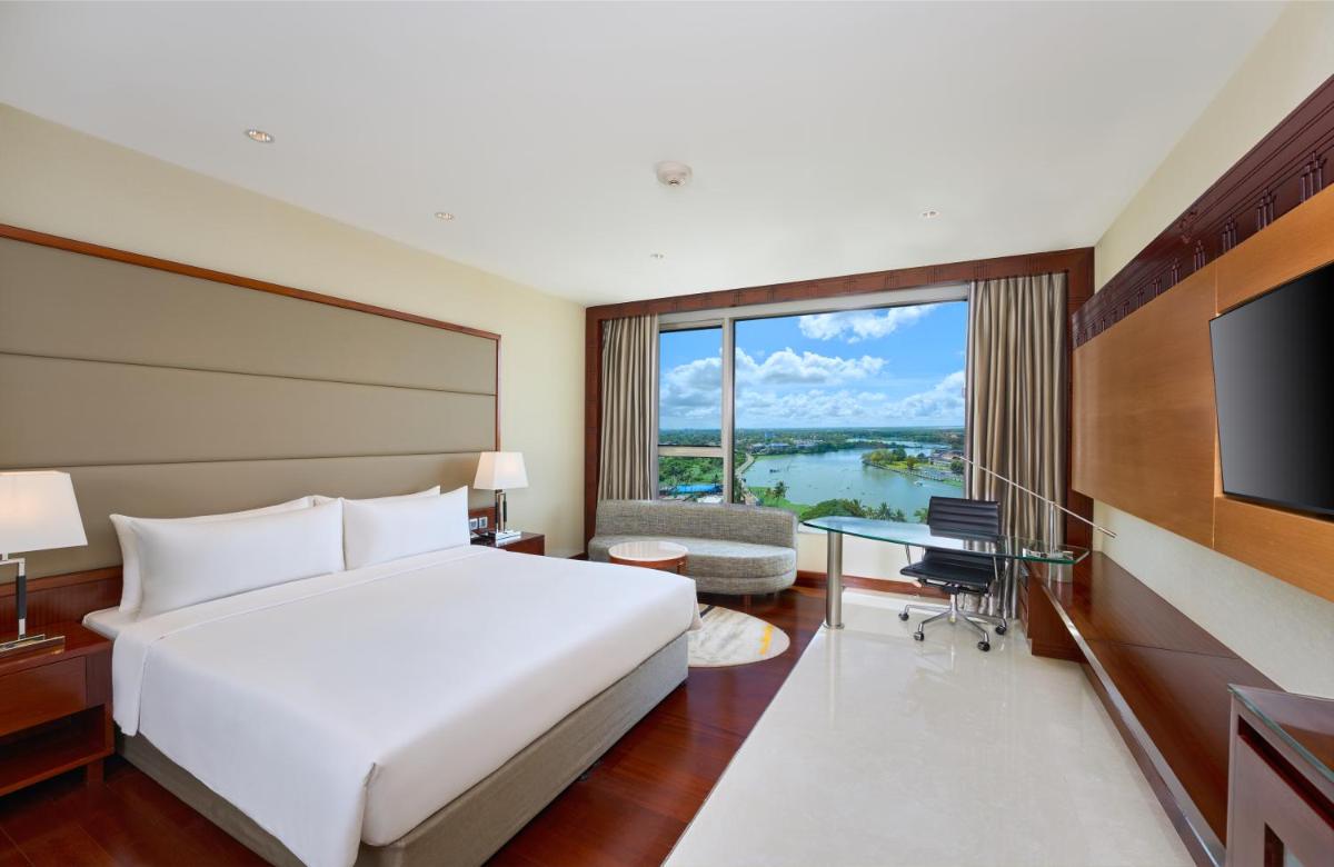 a hotel room with a bed and a large window at Crowne Plaza Kochi by IHG in Cochin