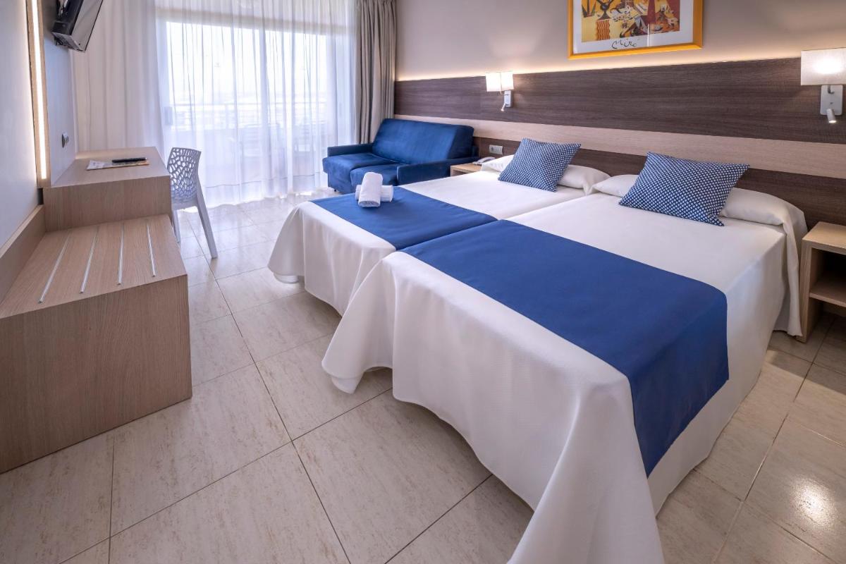 Una habitación de hotel con una cama grande y un sofá. en 4R Gran Regina, en Salou
