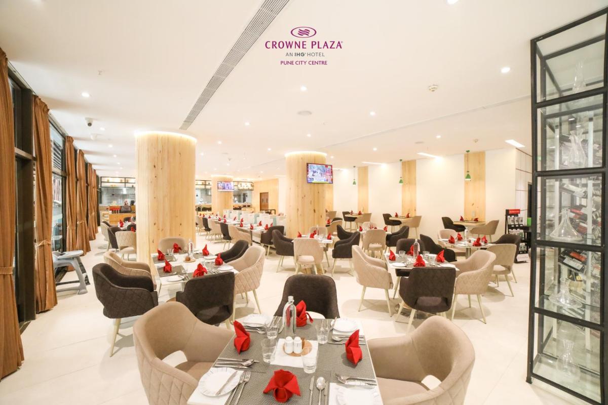 a restaurant with tables and chairs with red bows at Crowne Plaza Pune City Centre by IHG in Pune