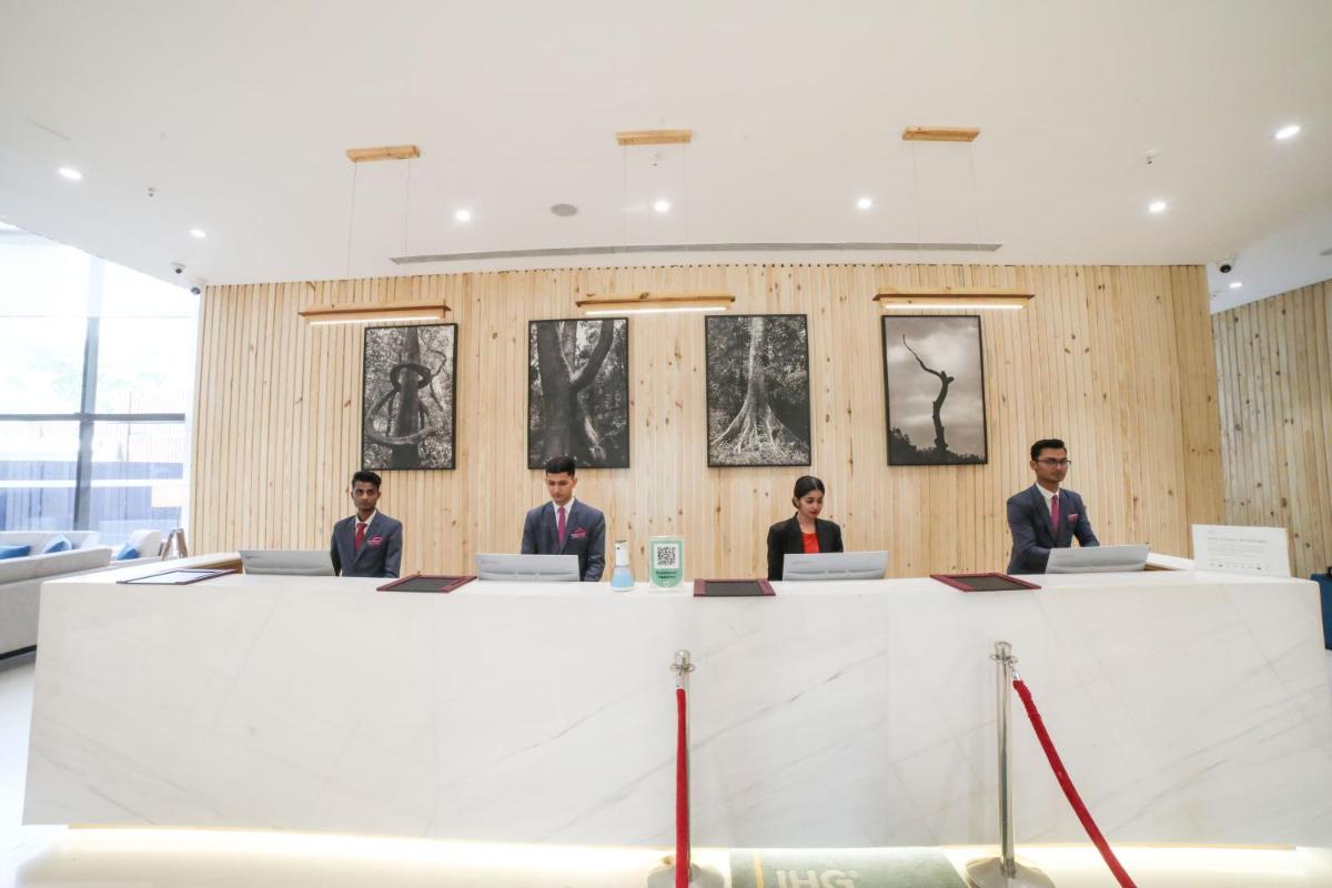 a group of men sitting at a table with laptops at Crowne Plaza Pune City Centre by IHG in Pune