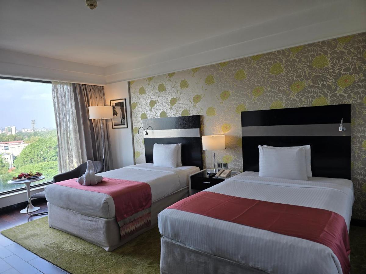 a hotel room with two beds and a window at Crowne Plaza Pune City Centre by IHG in Pune