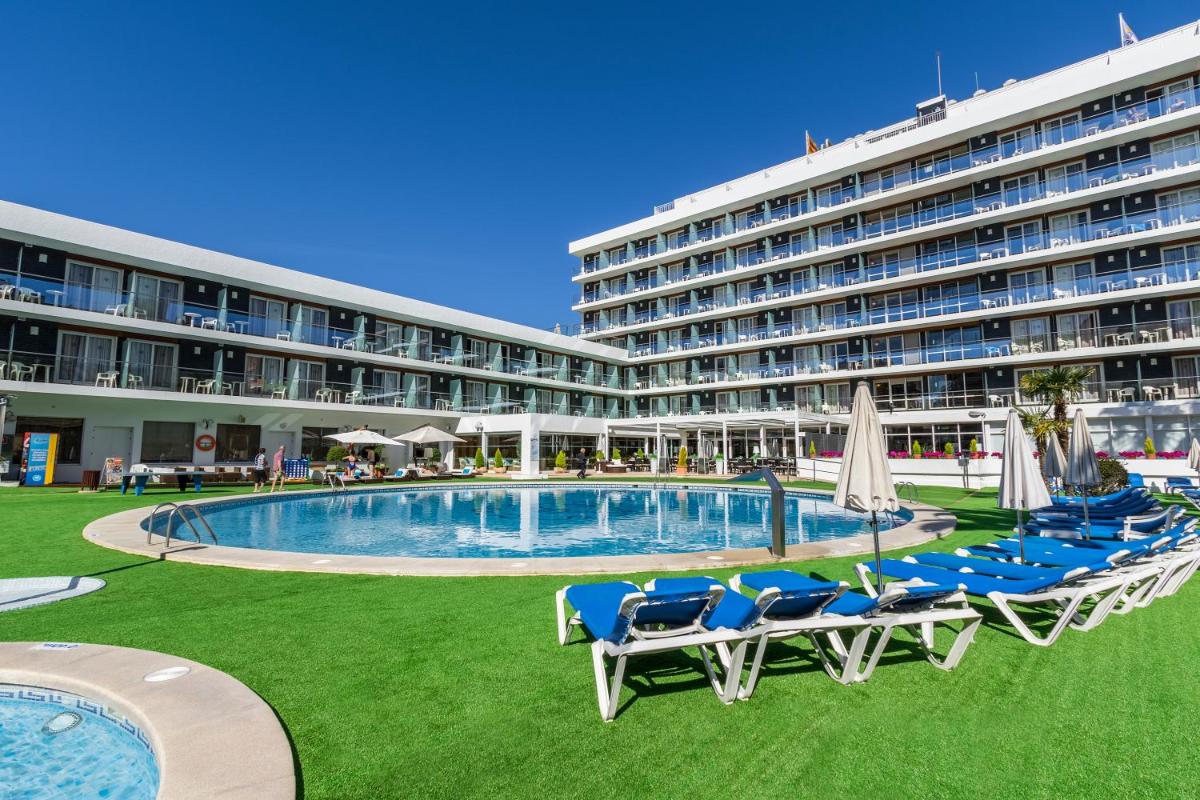 Un hotel con piscina y sillas y un edificio. en Hotel Anabel, en Lloret de Mar