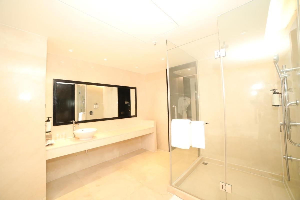 a bathroom with a sink and a glass shower at Crowne Plaza Pune City Centre by IHG in Pune