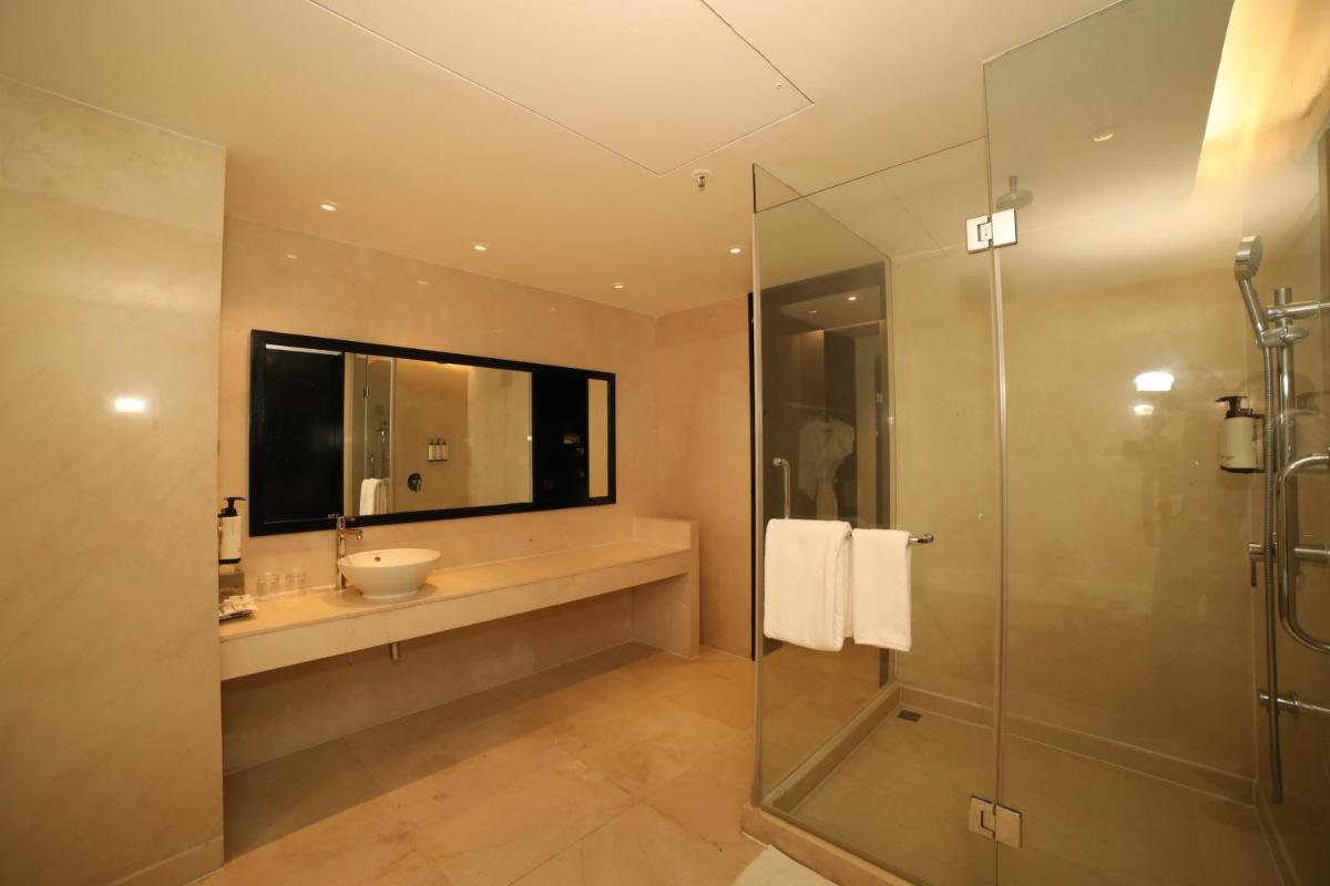 a bathroom with a sink and a glass shower at Crowne Plaza Pune City Centre by IHG in Pune