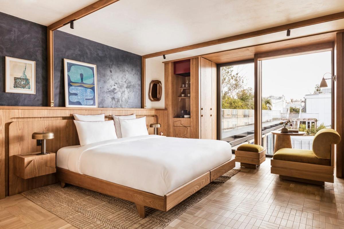 une chambre avec un grand lit et une grande fenêtre dans l'établissement La Fondation, à Paris