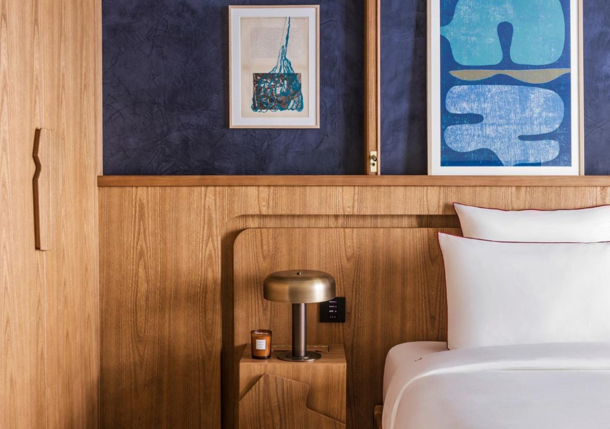 une chambre avec un lit et une table avec une lampe dans l'établissement La Fondation, à Paris