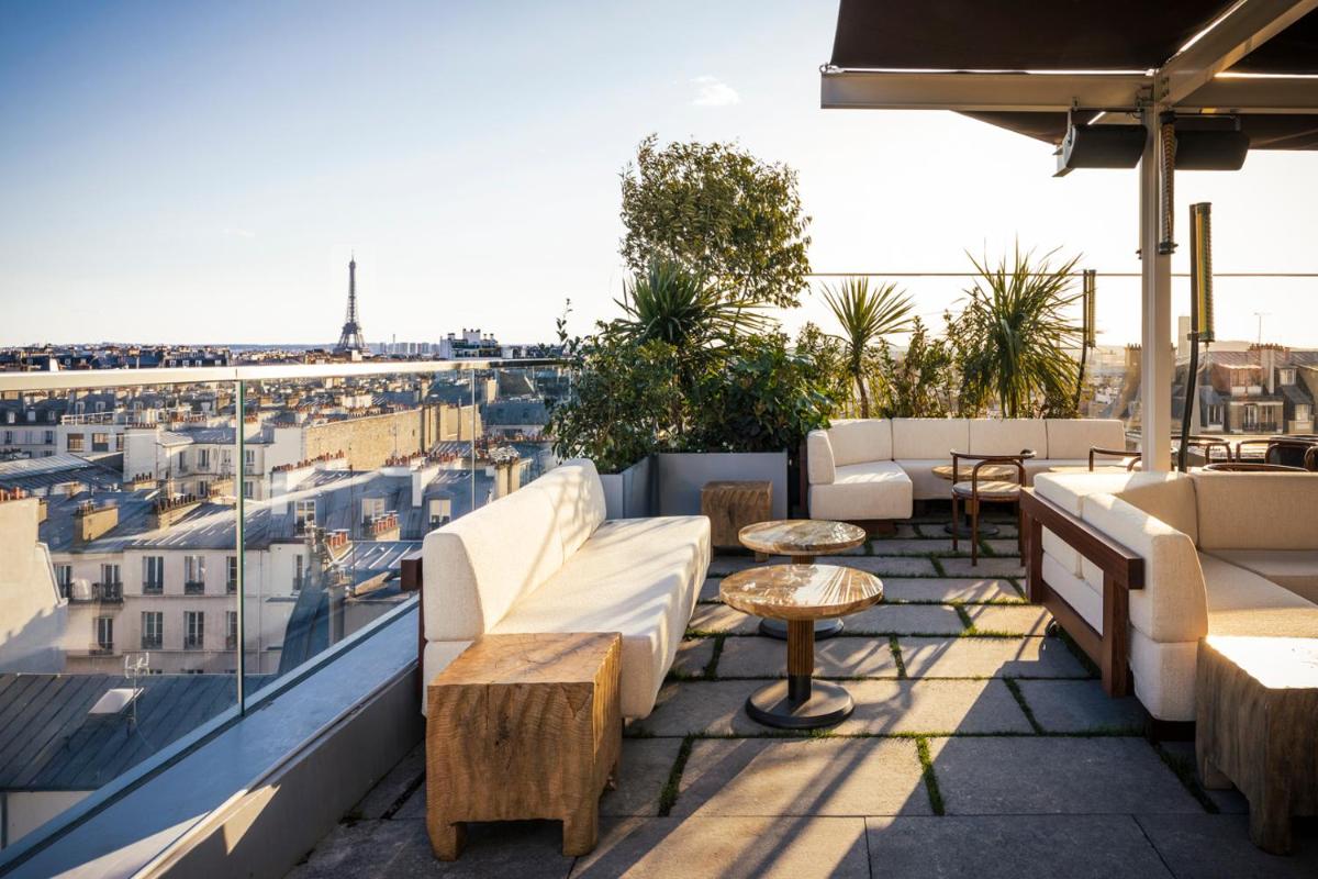 une terrasse avec des canapés et des tables sur le toit dans l'établissement La Fondation, à Paris