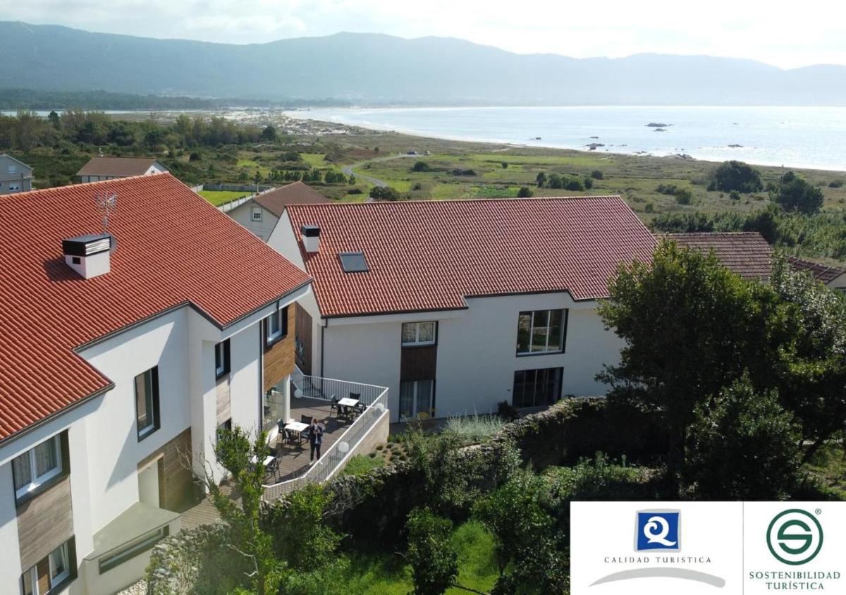 una imagen de una casa con vistas al océano en Hotel Spa Meiga do Mar, en Carnota