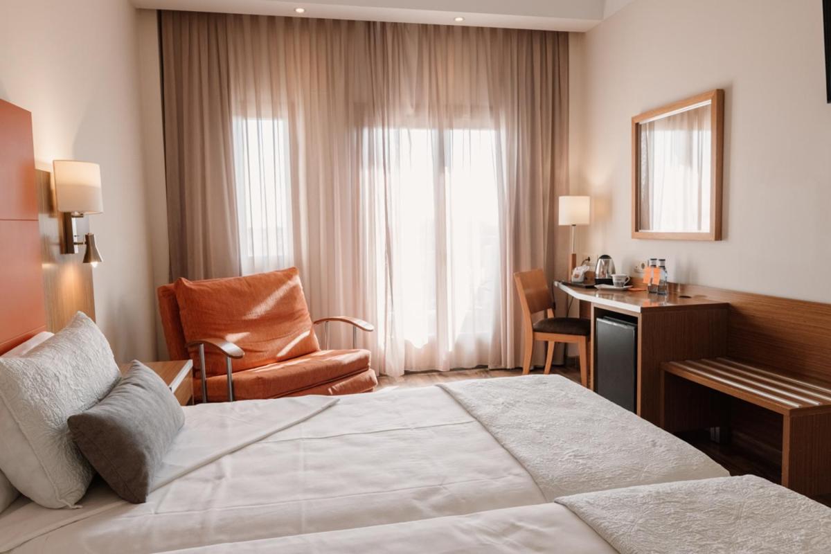 Una habitación de hotel con una cama grande y un escritorio. en Hotel Monarque Costa Narejos, en Los Alcázares