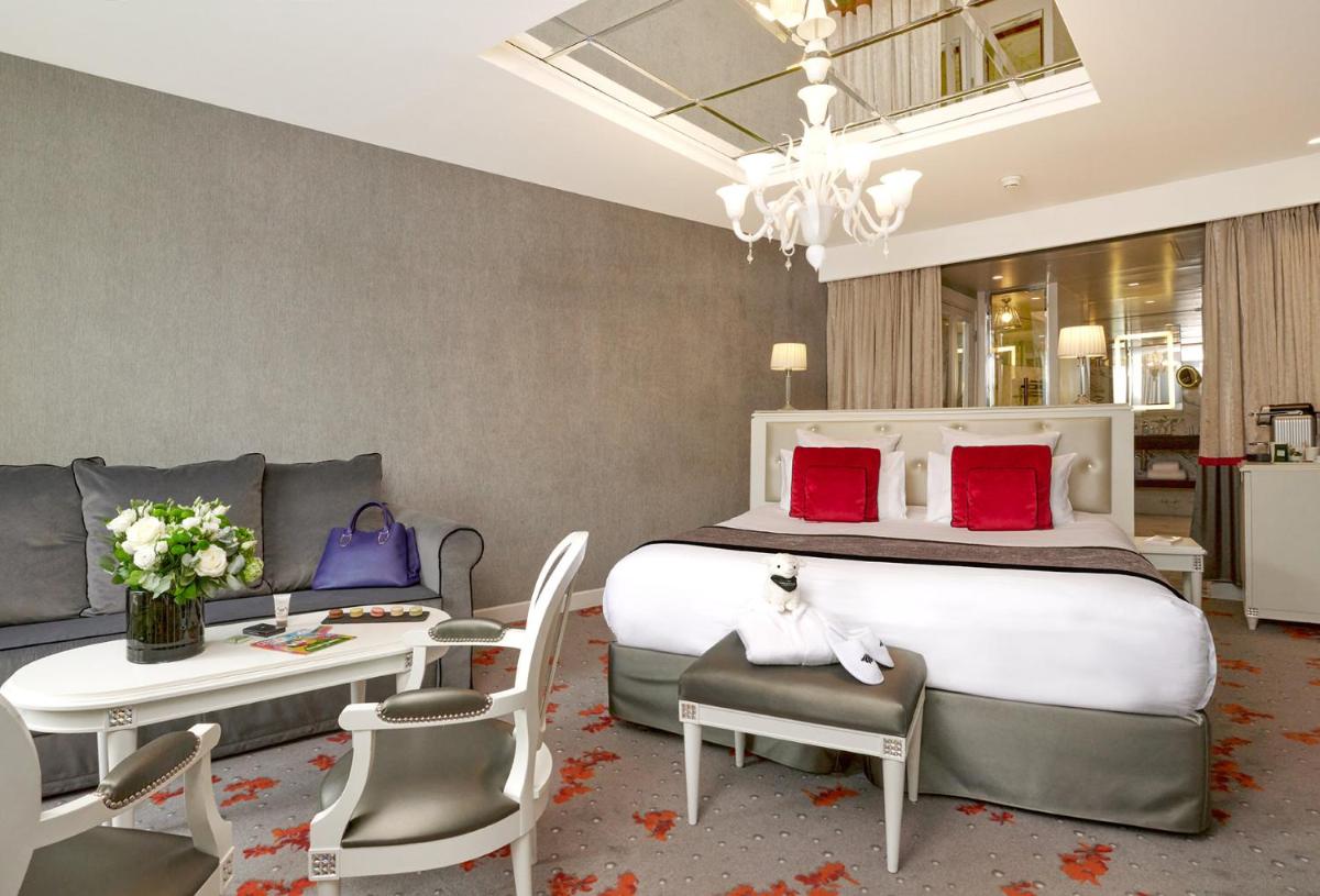 une chambre avec un grand lit avec des oreillers rouges dans l'établissement Maison Albar - Le Diamond, à Paris