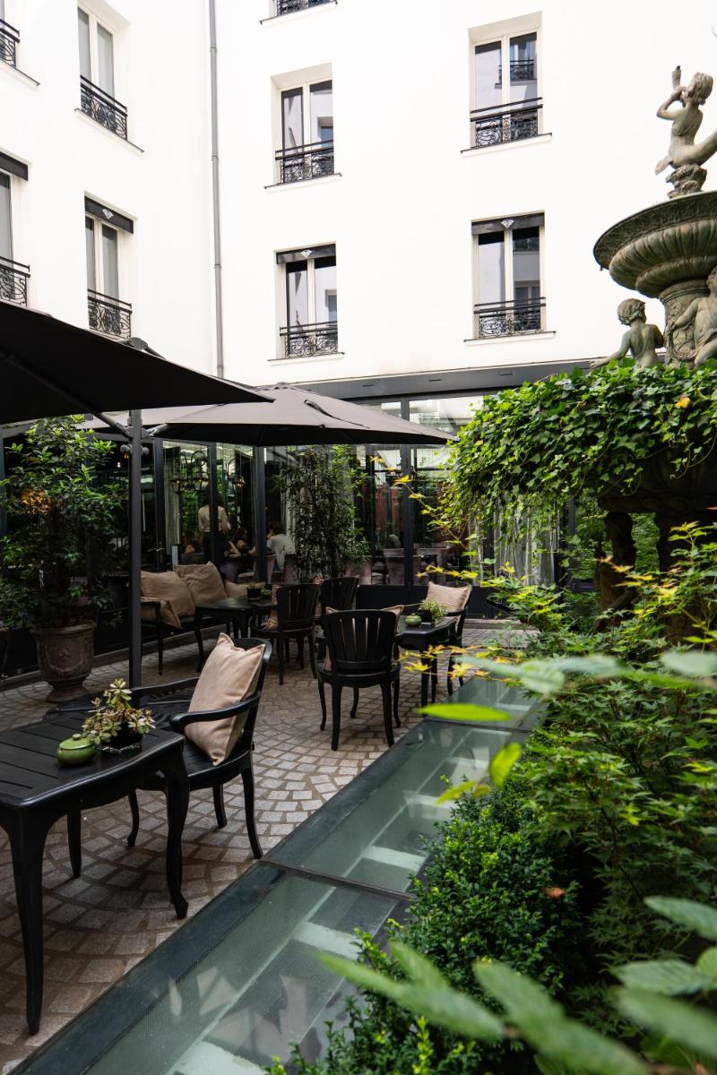 un patio avec une fontaine, des tables et des chaises dans l'établissement Maison Albar - Le Diamond, à Paris