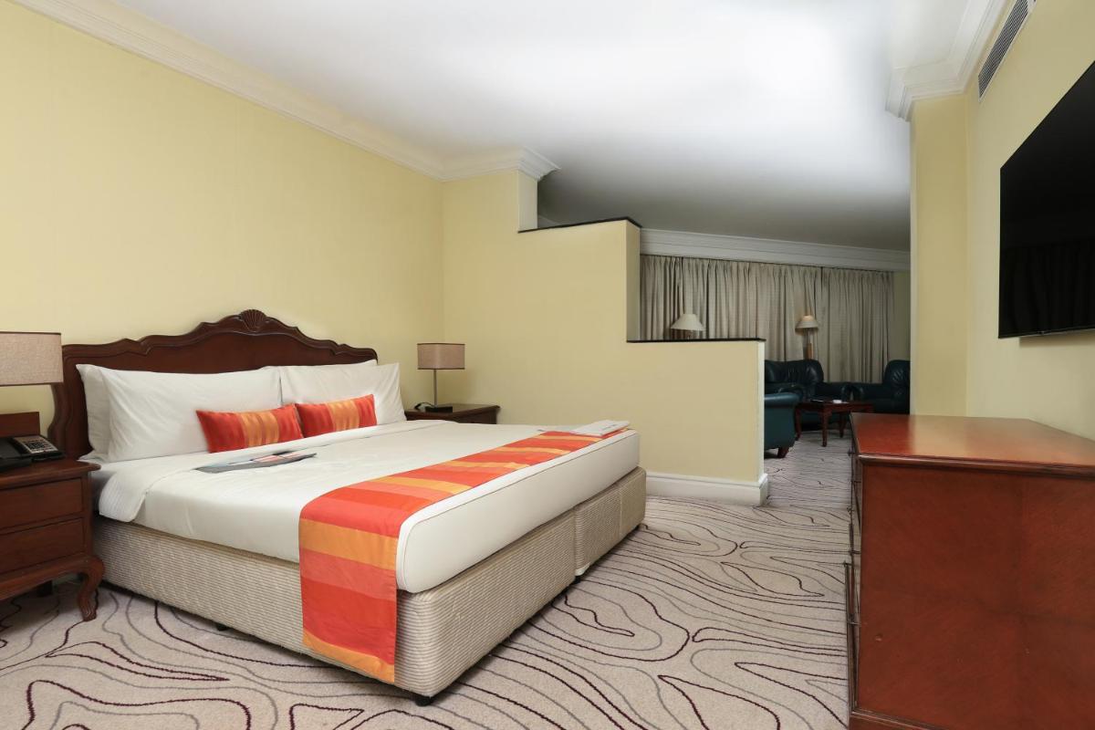 a hotel room with a bed and a television at Le Royal Meridien Chennai in Chennai