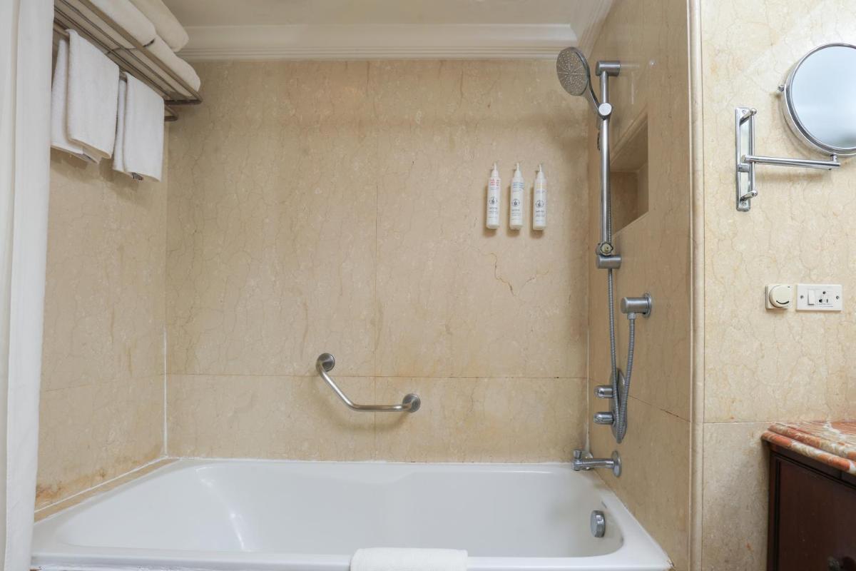 a bath tub in a bathroom with a shower at Le Royal Meridien Chennai in Chennai