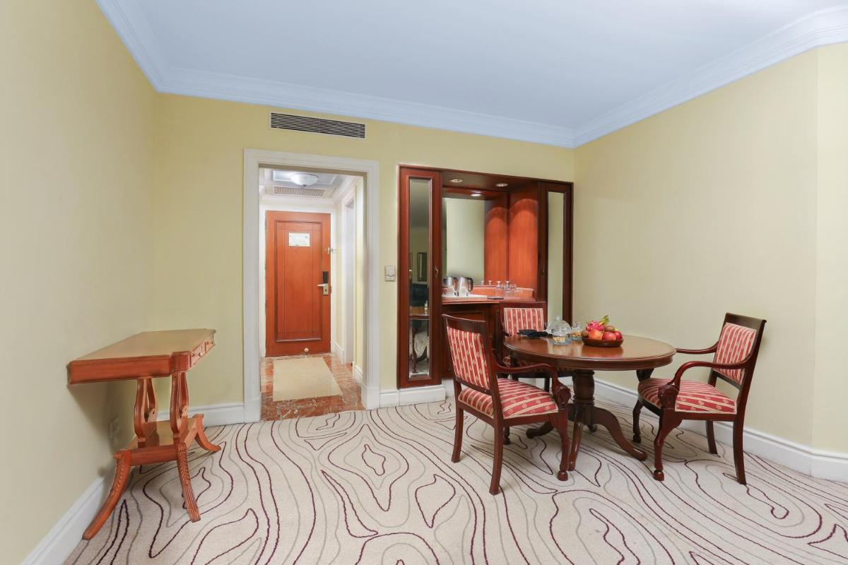 a dining room with a table and chairs and a desk at Le Royal Meridien Chennai in Chennai