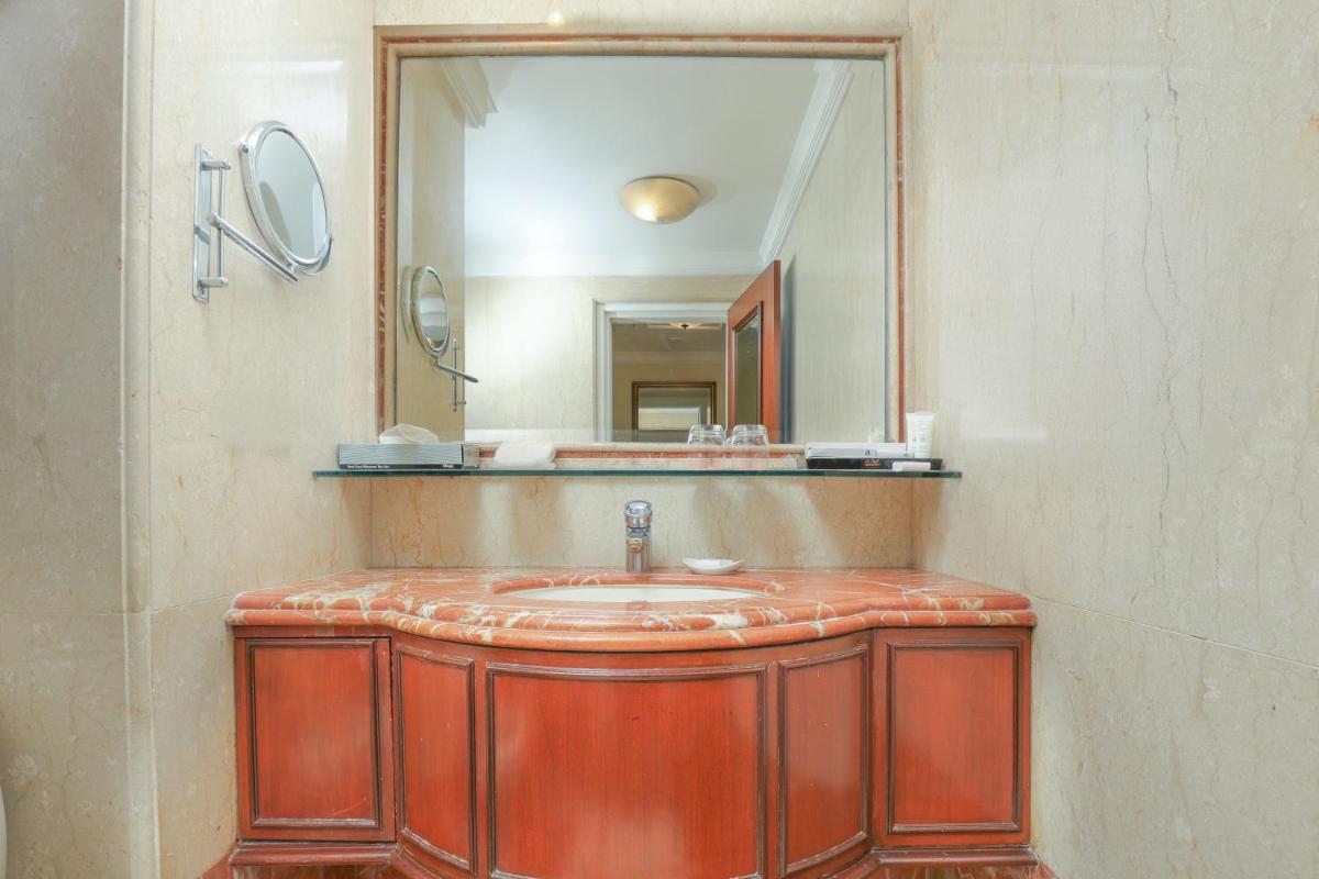 a bathroom with a sink and a large mirror at Le Royal Meridien Chennai in Chennai