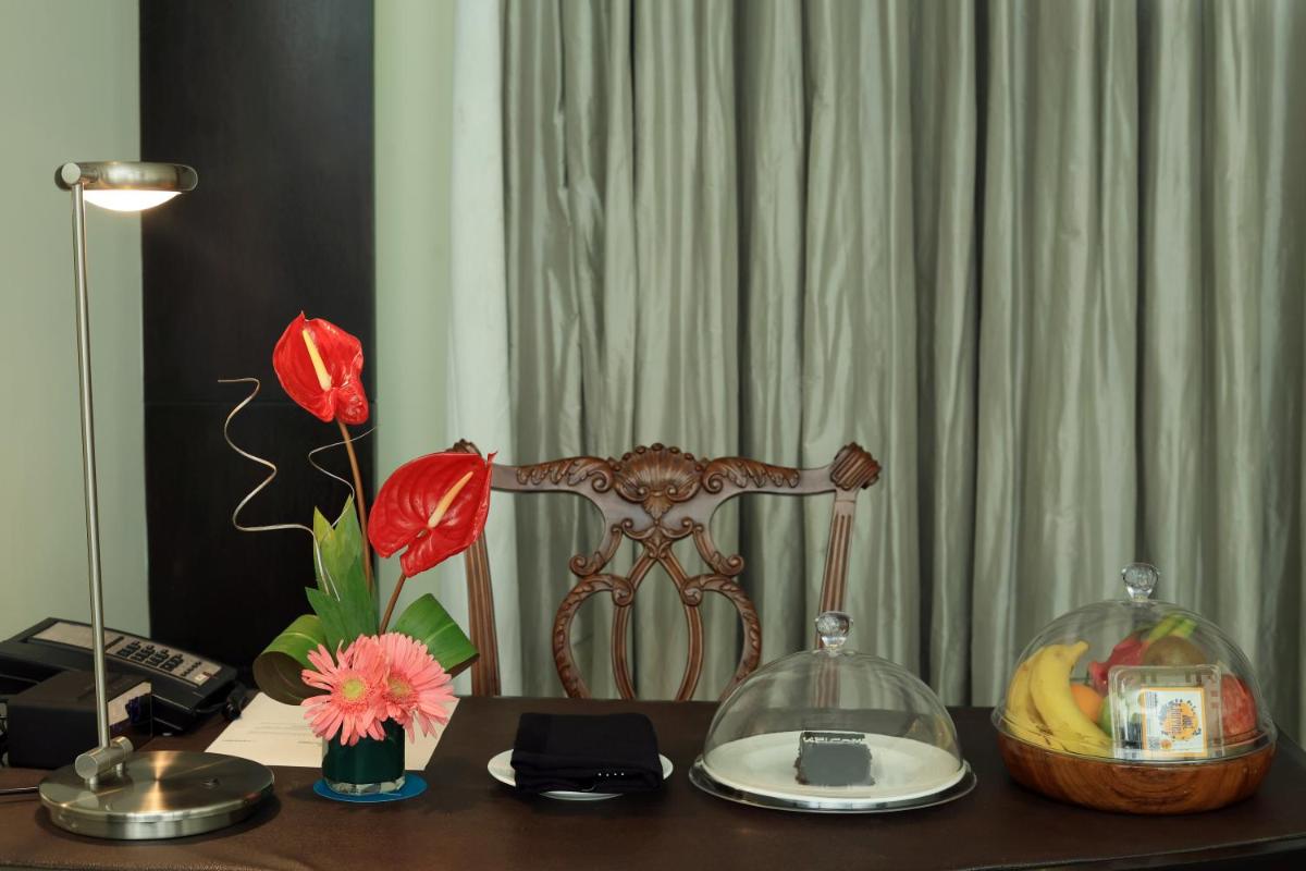 a desk with a flower and a glass bowl on it at Le Royal Meridien Chennai in Chennai