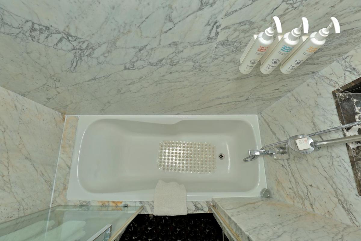 a bathroom with a urinal in a marble wall at Le Royal Meridien Chennai in Chennai