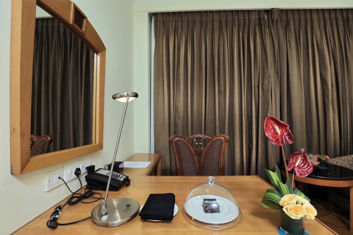 a desk with a lamp on top of a table at Le Royal Meridien Chennai in Chennai