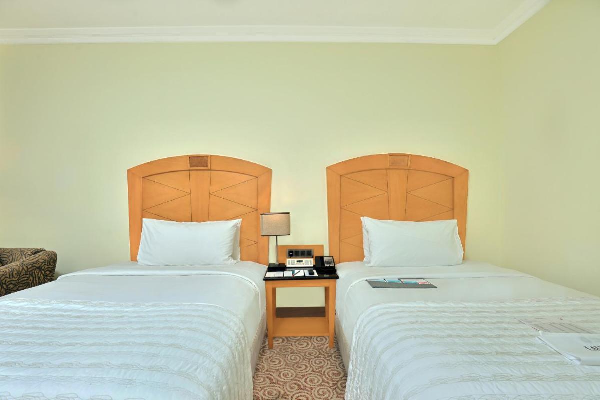 two beds sitting next to each other in a room at Le Royal Meridien Chennai in Chennai