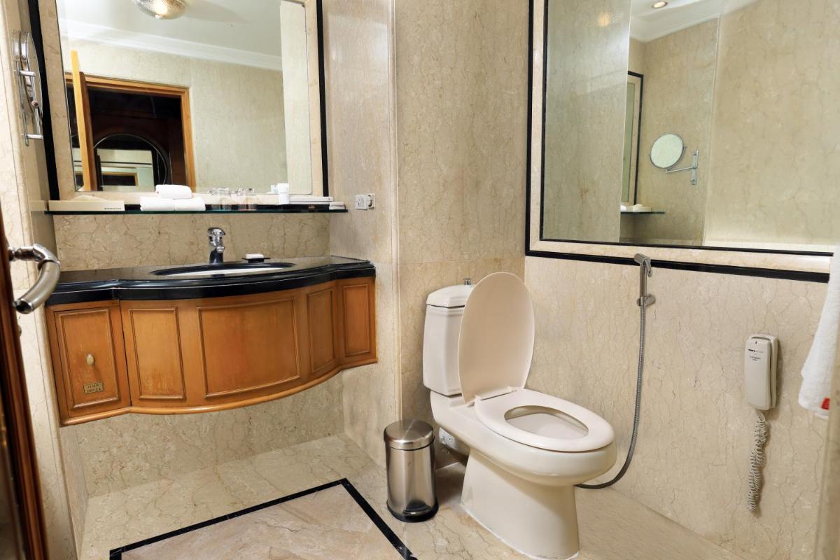 a bathroom with a toilet and a sink at Le Royal Meridien Chennai in Chennai