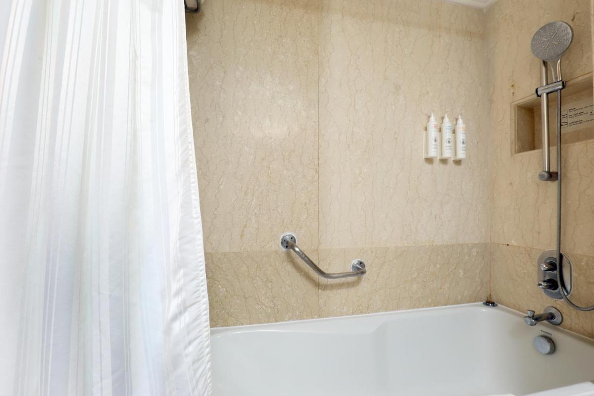 a bathroom with a shower with a shower curtain at Le Royal Meridien Chennai in Chennai
