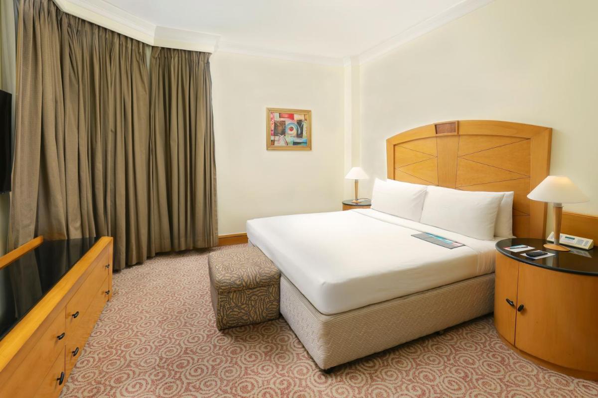 a hotel room with a large bed and a television at Le Royal Meridien Chennai in Chennai
