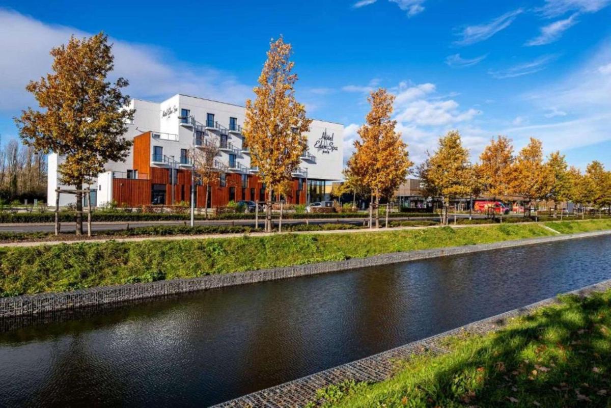 une rivière avec des arbres devant un bâtiment dans l'établissement Best Western Eden SPA, à Honfleur