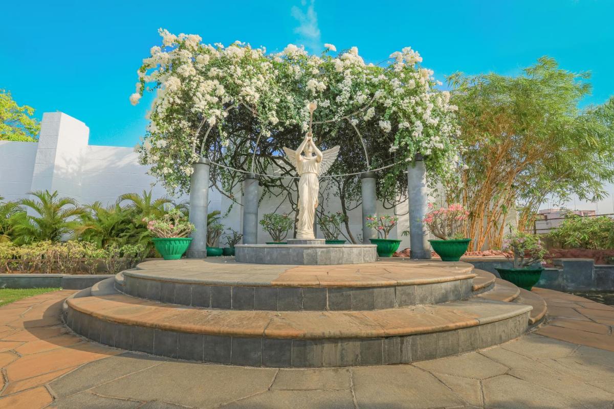 a statue of a woman with flowers in a park at Le Royal Meridien Chennai in Chennai