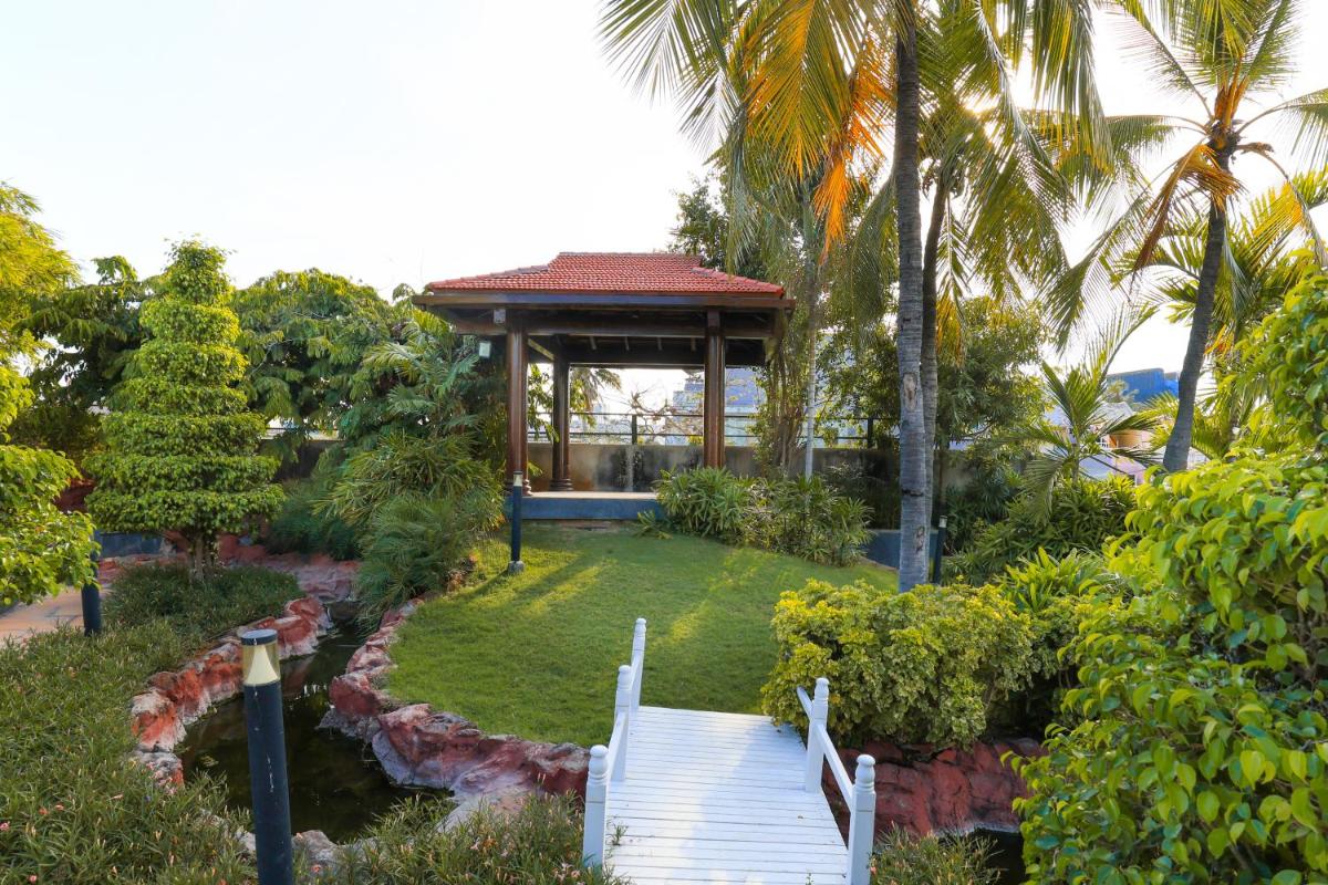 a gazebo with a staircase in a garden at Le Royal Meridien Chennai in Chennai