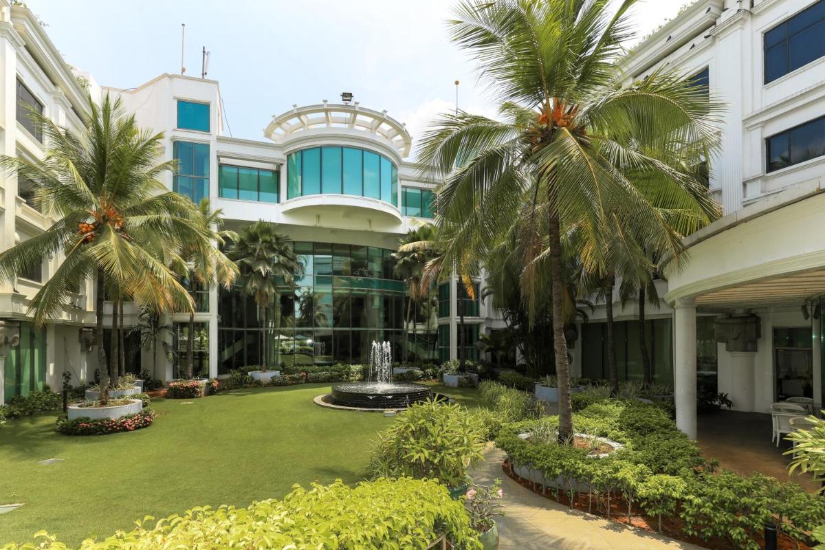 a large building with palm trees in front of it at Le Royal Meridien Chennai in Chennai