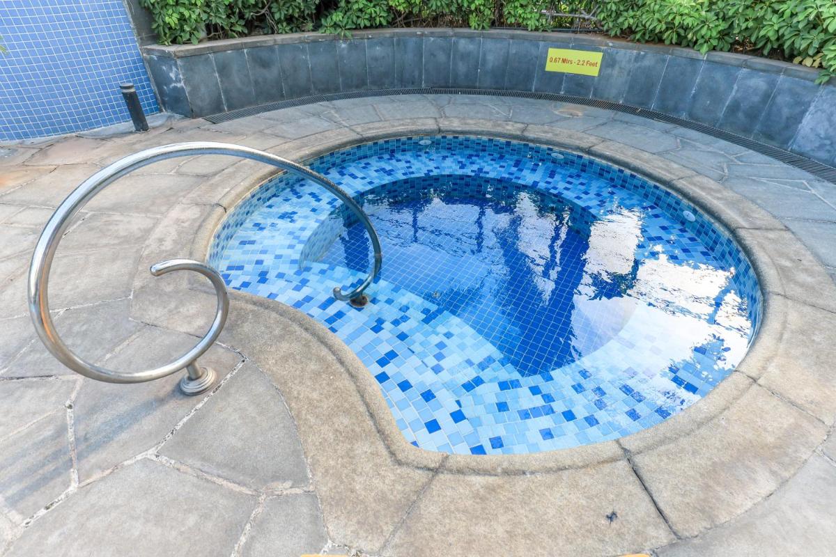 a swimming pool with blue tiles on the ground at Le Royal Meridien Chennai in Chennai