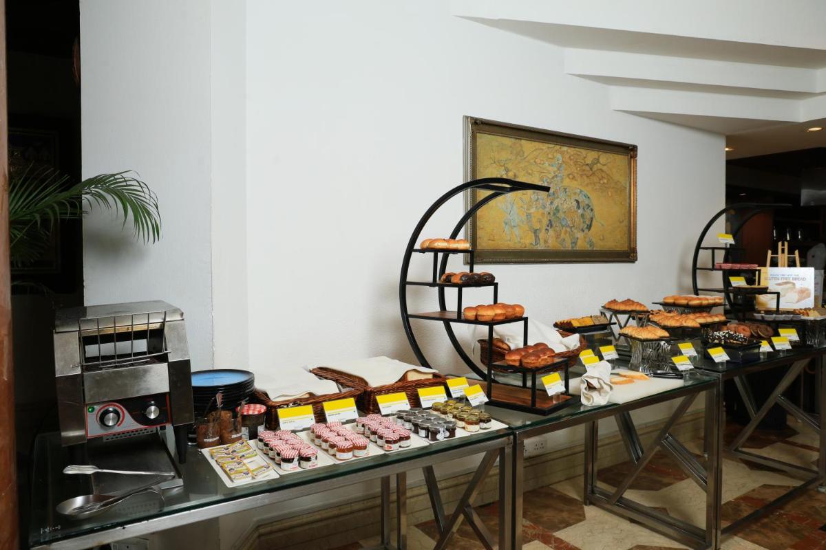 a table filled with different types of sandwiches and pastries at Le Royal Meridien Chennai in Chennai
