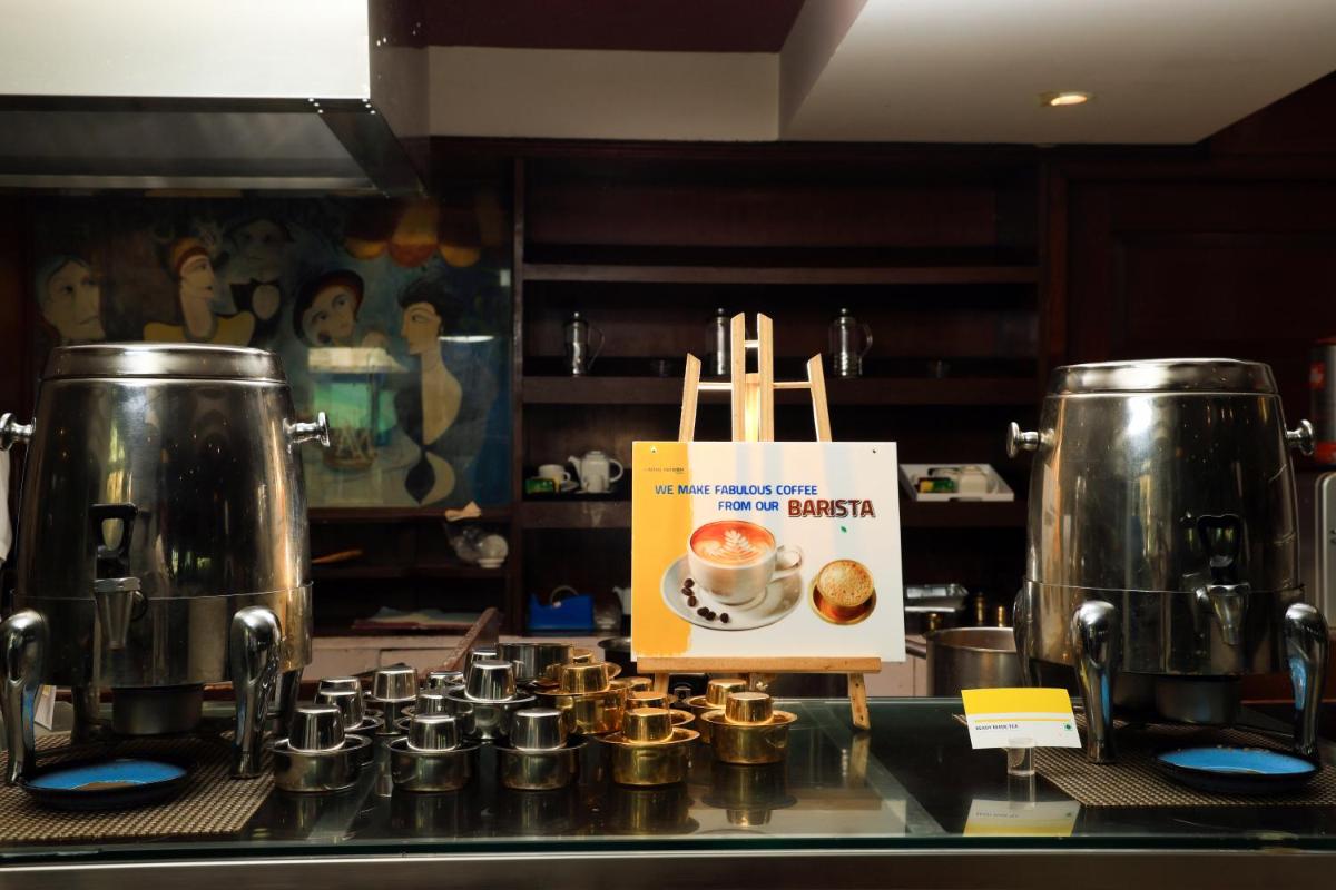 a counter with two large coffee pots and a sign at Le Royal Meridien Chennai in Chennai