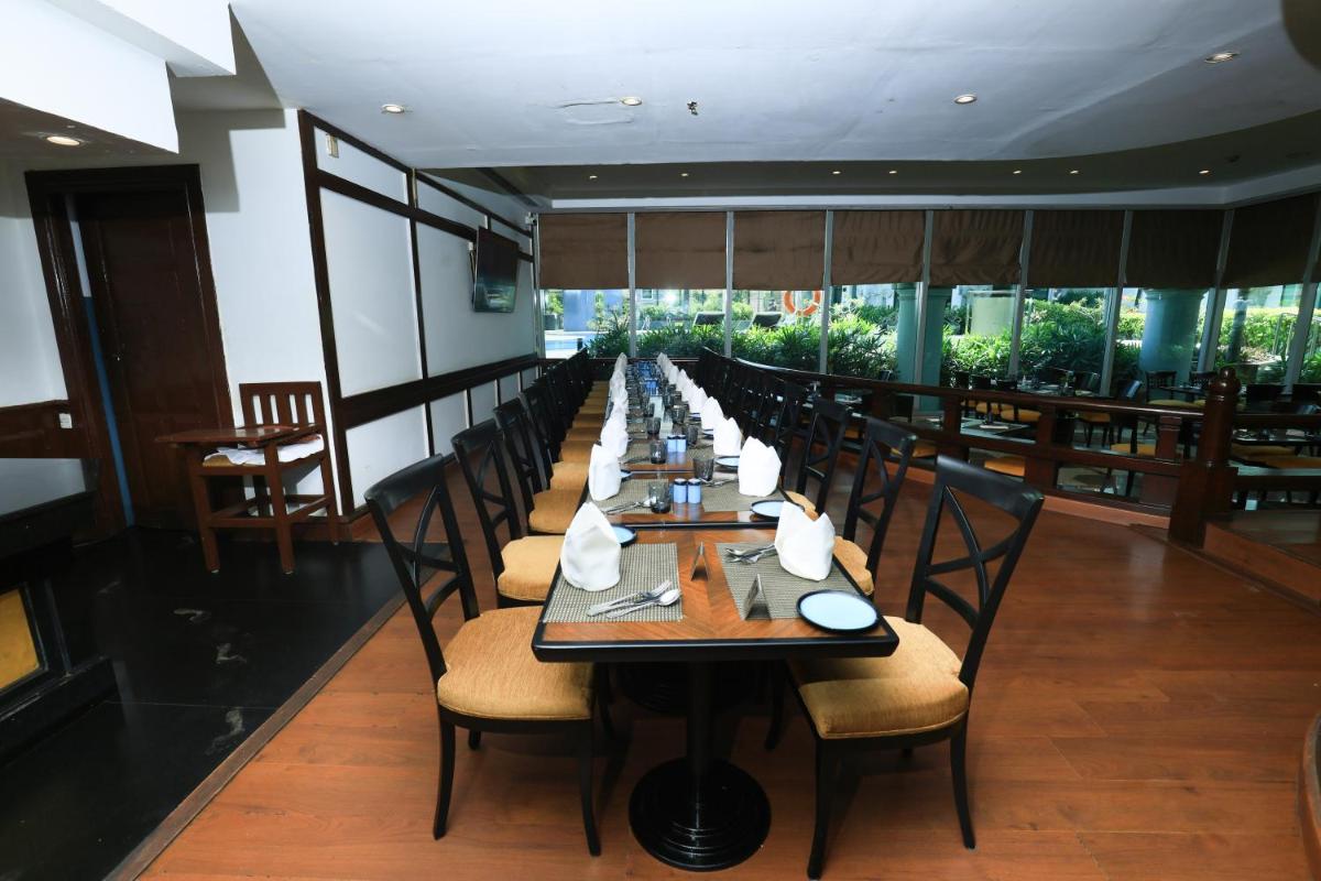 a long dining room with a long table with chairs at Le Royal Meridien Chennai in Chennai